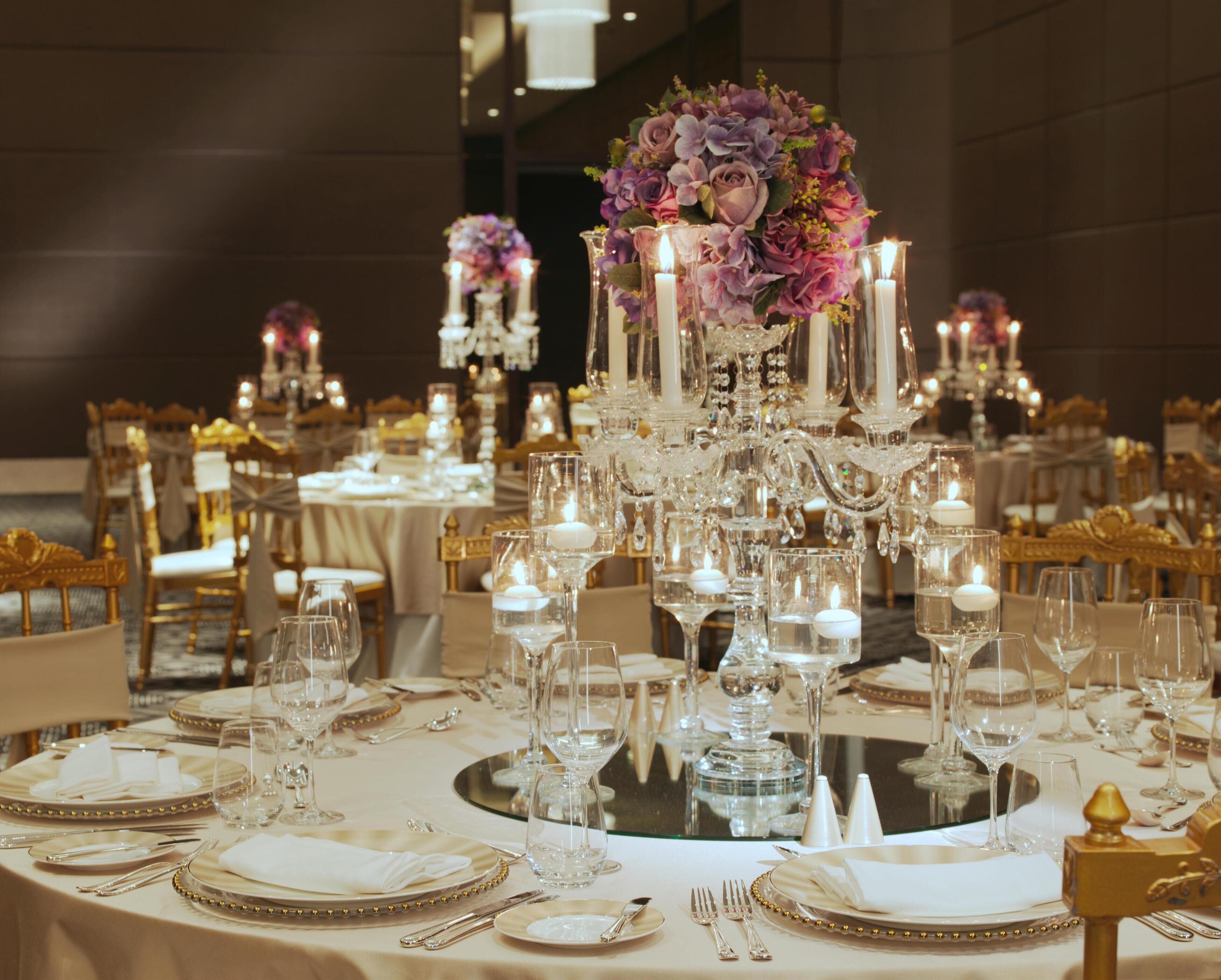 A banquet table set with fine china, crystal glassware, and elegant floral centerpieces.