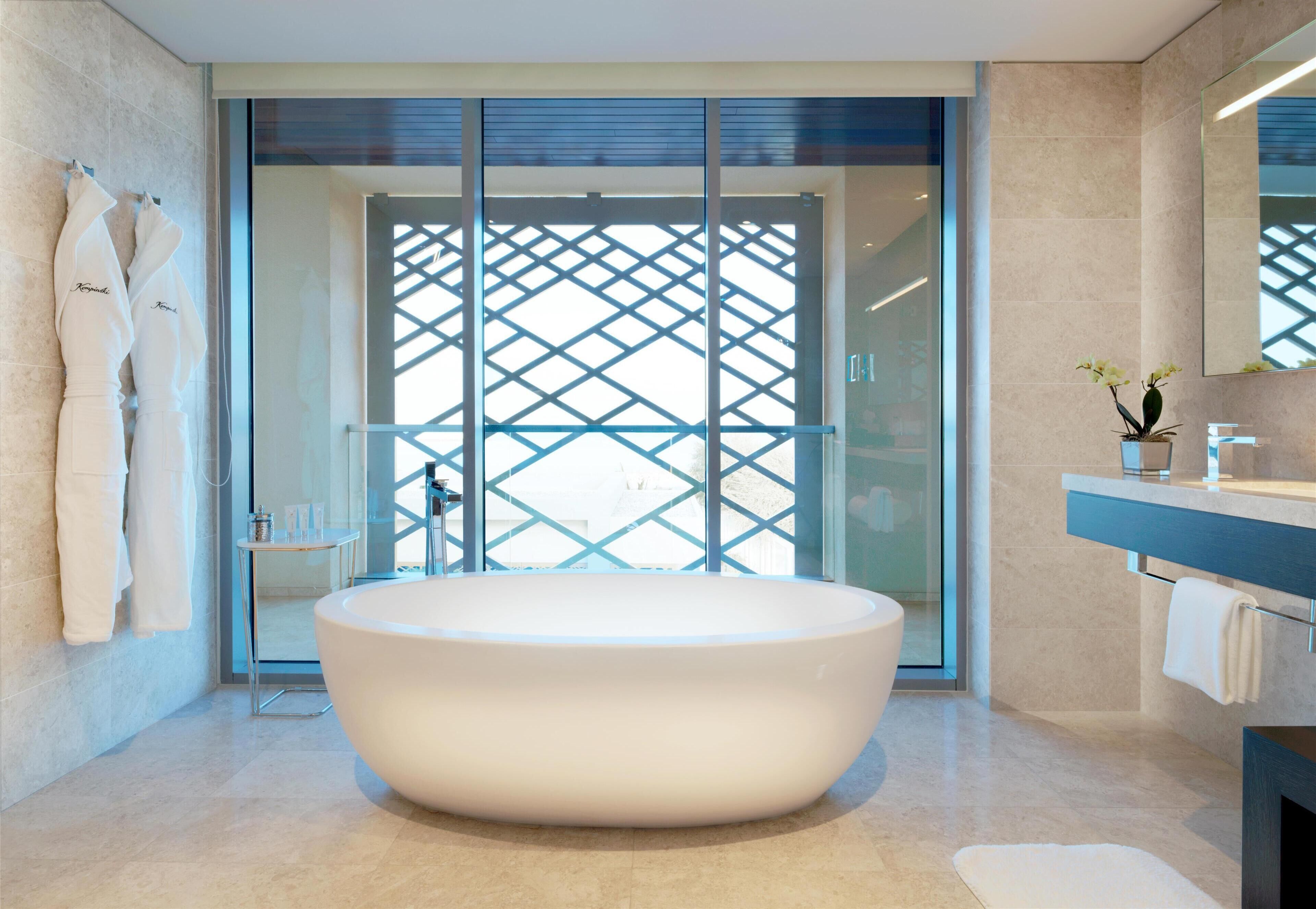 Une salle de bain moderne avec une baignoire sur pieds, une douche à parois de verre et un meuble-lavabo avec un miroir.