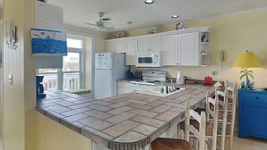A kitchen with white cabinets, a tiled island, a microwave, and a sink. - Bright's Beach Front | Sound View + Walk to Beach! (Topsail Beach)