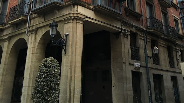 A multi-story building with a red brick facade, multiple balconies with wrought iron railings, and large windows. - Pensión La Bilbaina - Albergue Logroño (Logroño)