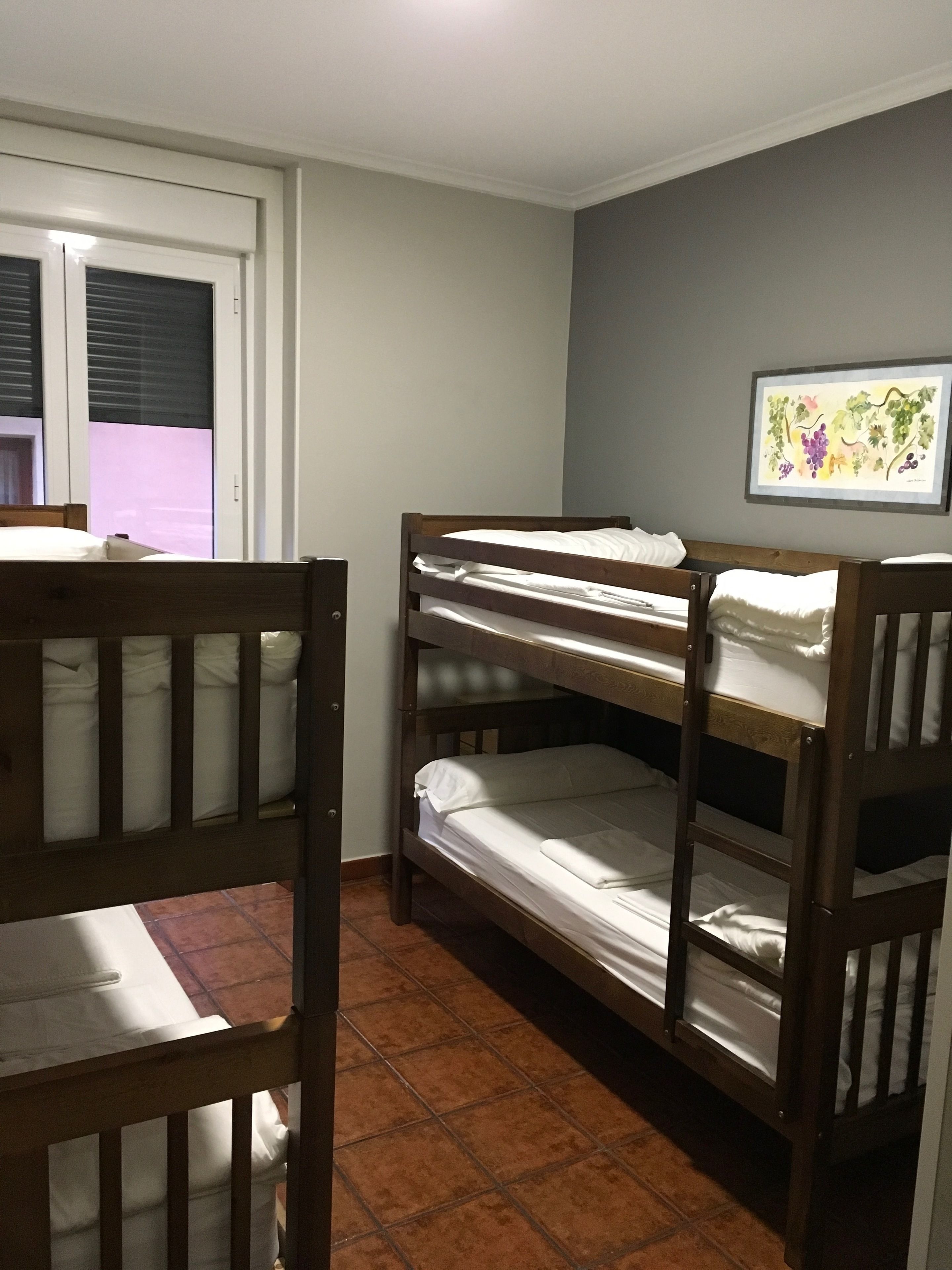 Un dormitorio con literas, una puerta y un cuadro colgado en la pared.
