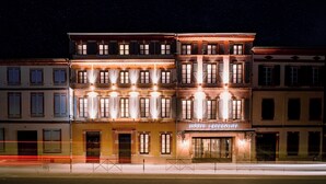 Un hotel con fachada clásica, múltiples ventanas y un letrero que indica que es un hotel.