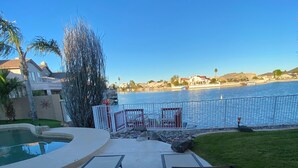 A poolside area with lounge chairs and a view of a body of water.