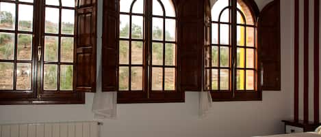 Escritorio, cortinas blackout y tabla de planchar con plancha