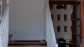 A staircase with a red carpet, white railing, and a wall with framed pictures.