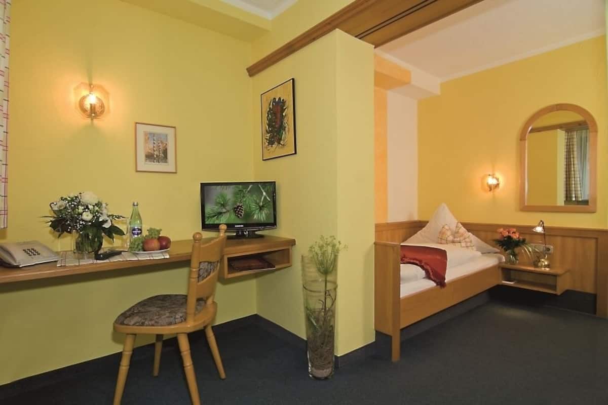 Une chambre d’hôtel équipée d’un lit, d’un bureau, d’une chaise et d’un téléviseur.