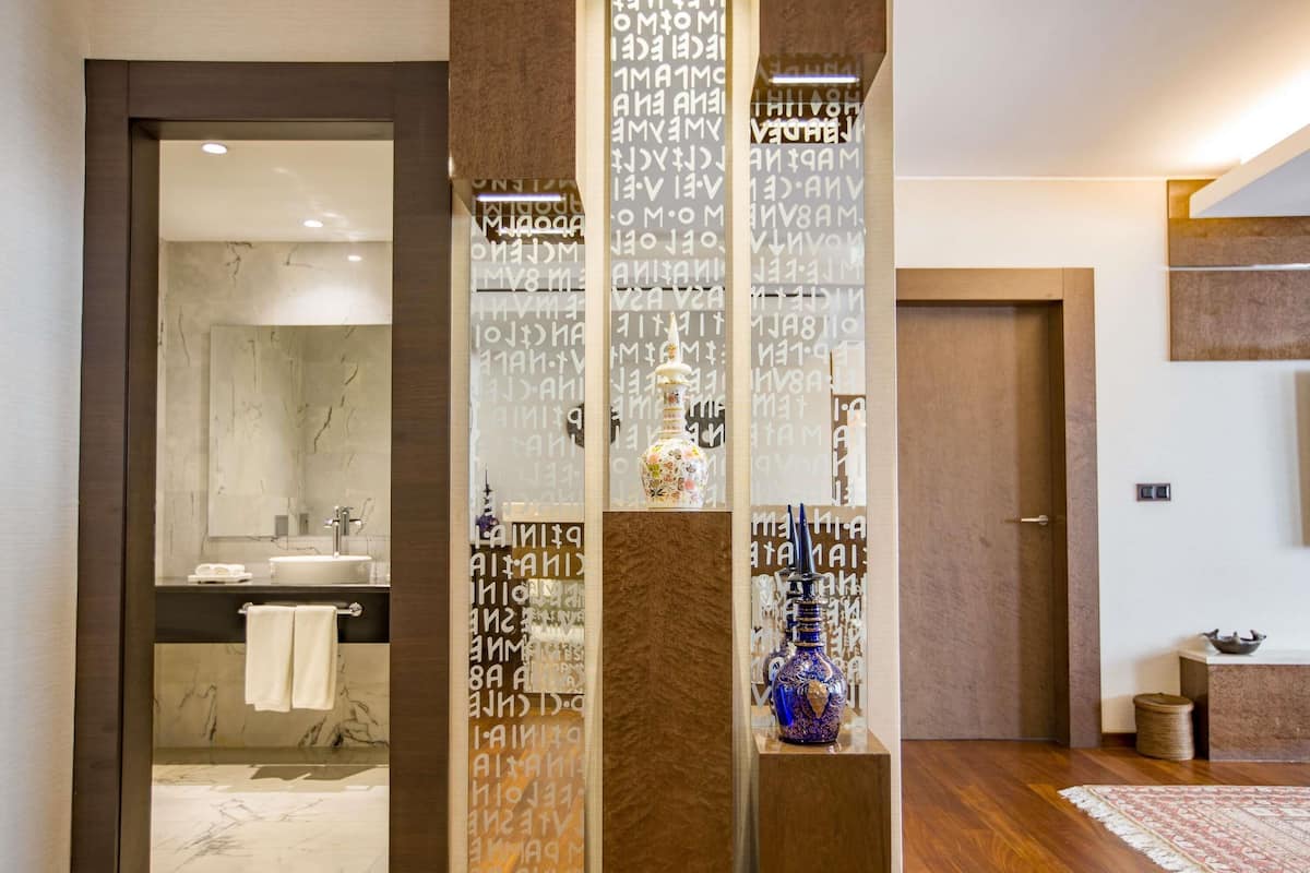Une salle de bain moderne avec un lavabo en marbre, un porte-serviettes et un vase décoratif.