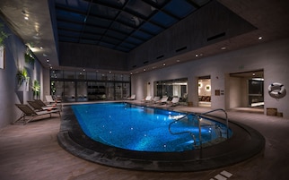 Una piscina techada, sillones reclinables de piscina