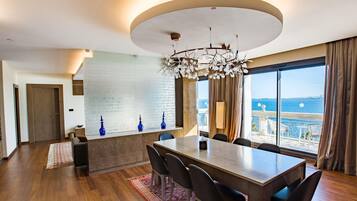Un comedor moderno con una mesa grande, sillas y vista al mar.