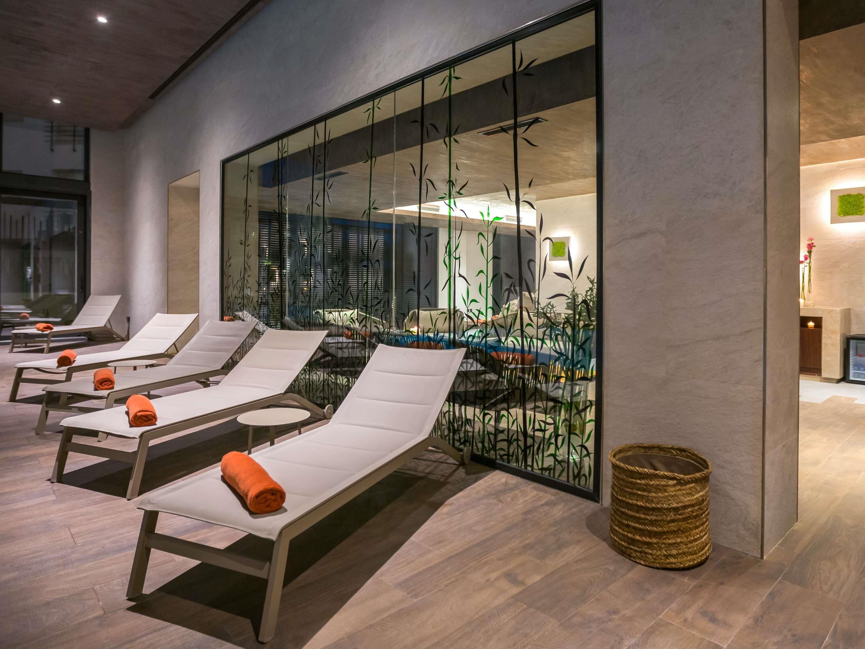 Una piscina techada, sillones reclinables de piscina