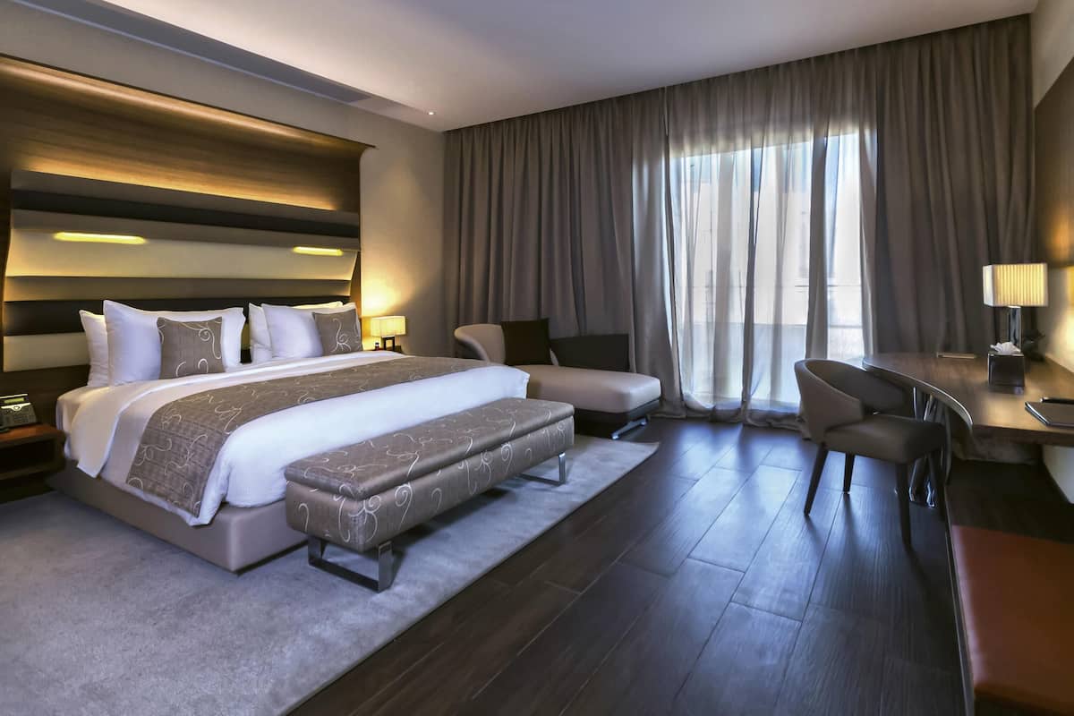 Une chambre d’hôtel moderne, dotée d’un grand lit, d’un bureau et d’une chaise.