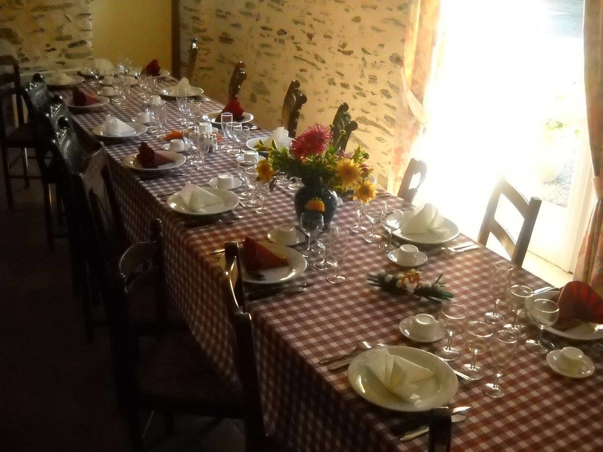 A dining area with checkered tablecloths, neatly set tables with plates, glasses, and cutlery.