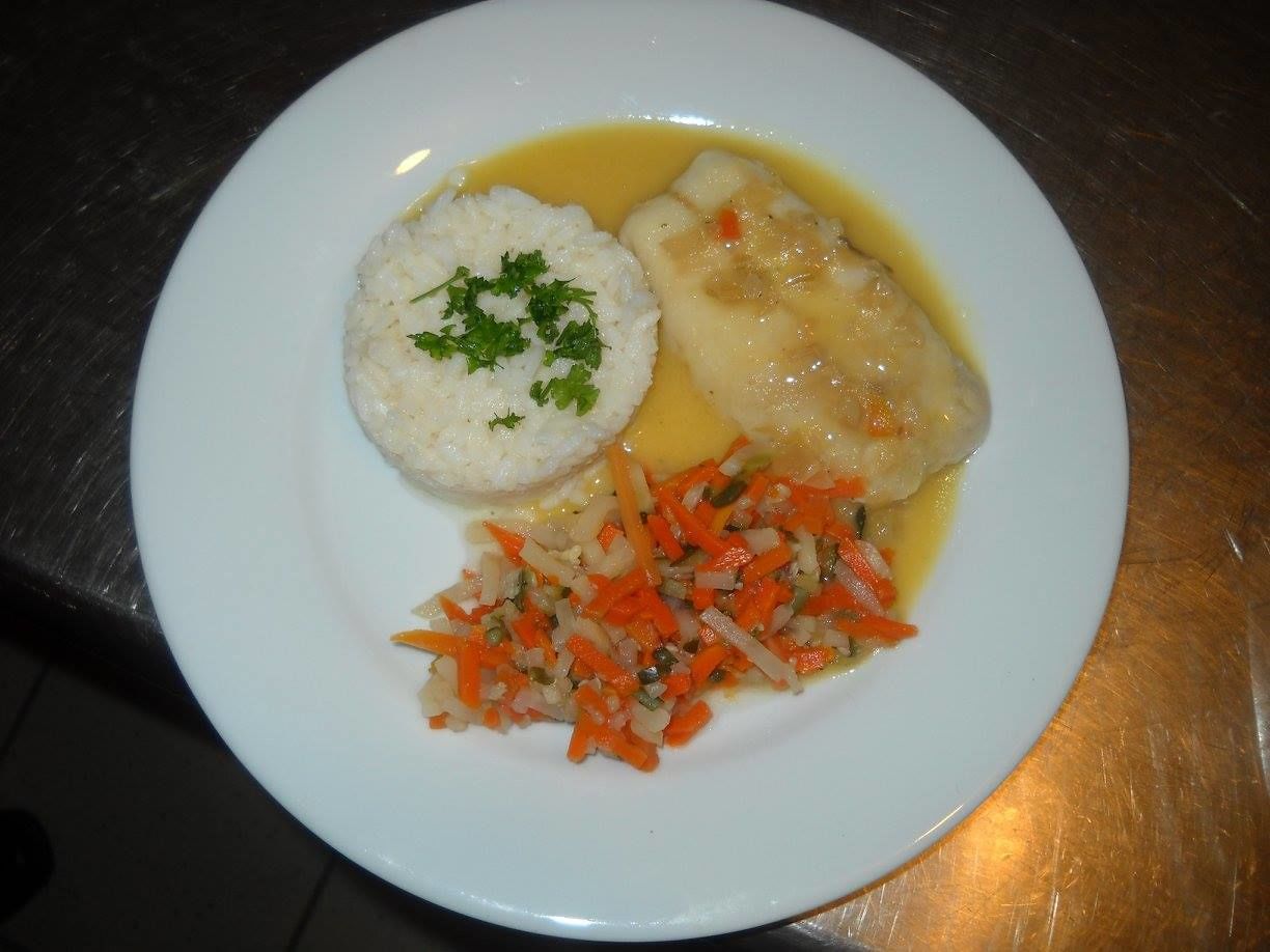 Un plato con dos albóndigas, puré de papas y un acompañamiento de verduras.
