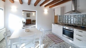 A modern kitchen with white cabinets, a stainless steel range hood, and a tiled backsplash. - Pretty House In Quiet And Traditional Neighborhood (Venezia)
