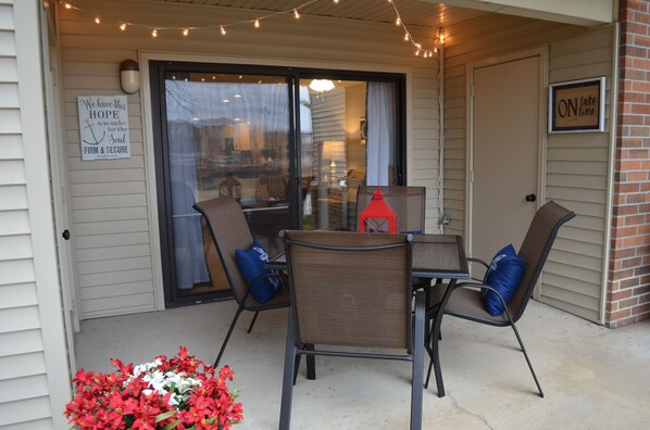 An outdoor patio with a table and chairs, a red lantern, and a sign saying "ON lake time".