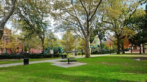 A park with green grass, trees, a playground, and a picnic table. - 1 Bedroom Apt Hoboken  - Close to NYC/MetLife - FIFA (Hoboken)