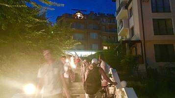 A staircase with people ascending, surrounded by buildings and greenery.