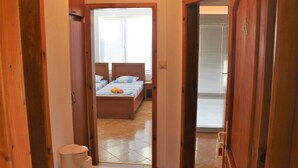 Quarto com cama, mesas de cabeceira e janela com persianas.