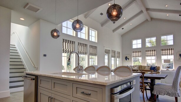 A spacious kitchen with a large island, modern appliances, and a dining area with a table and chairs.