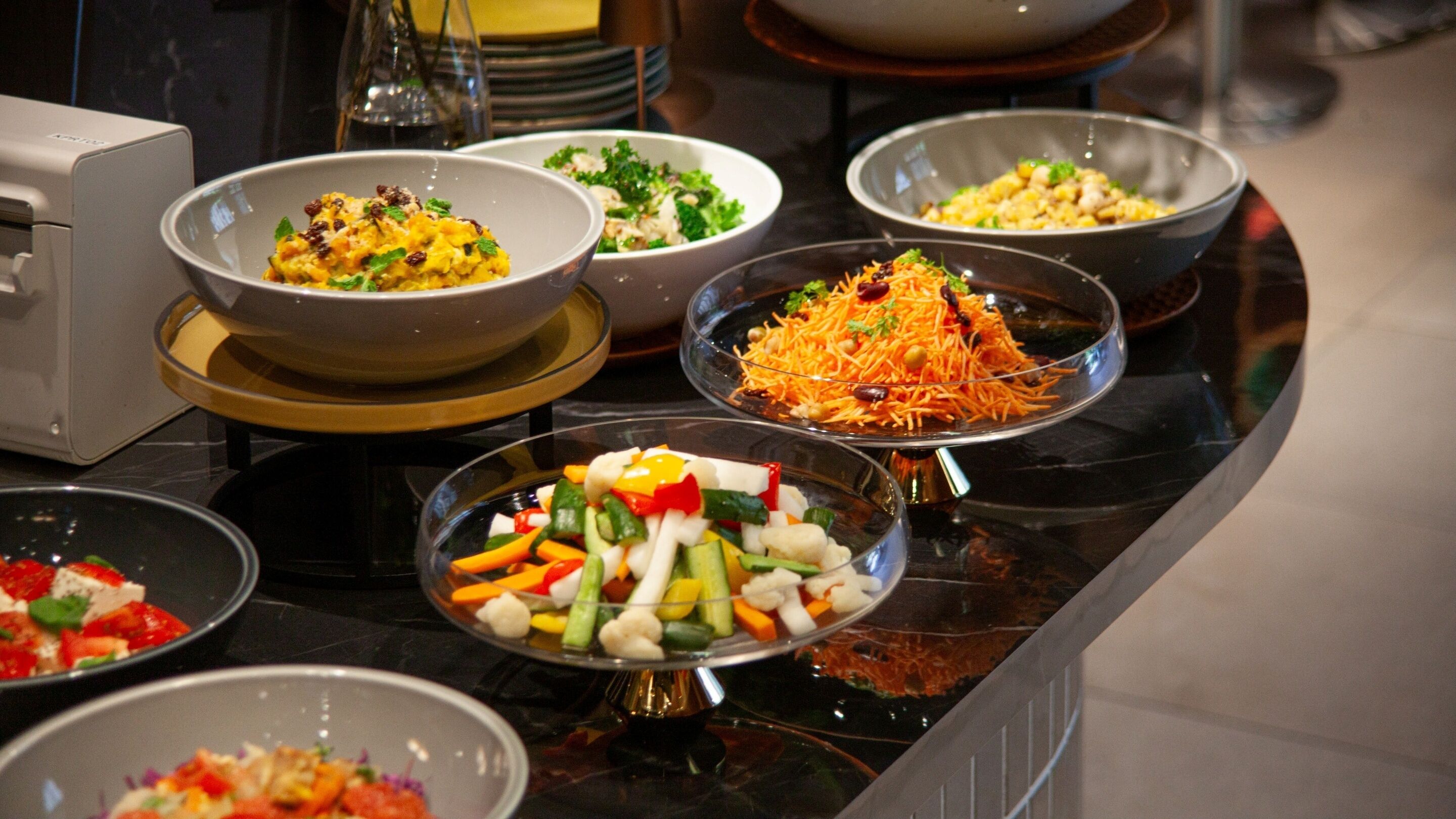 A buffet with various dishes including salads, rice, and mixed vegetables.