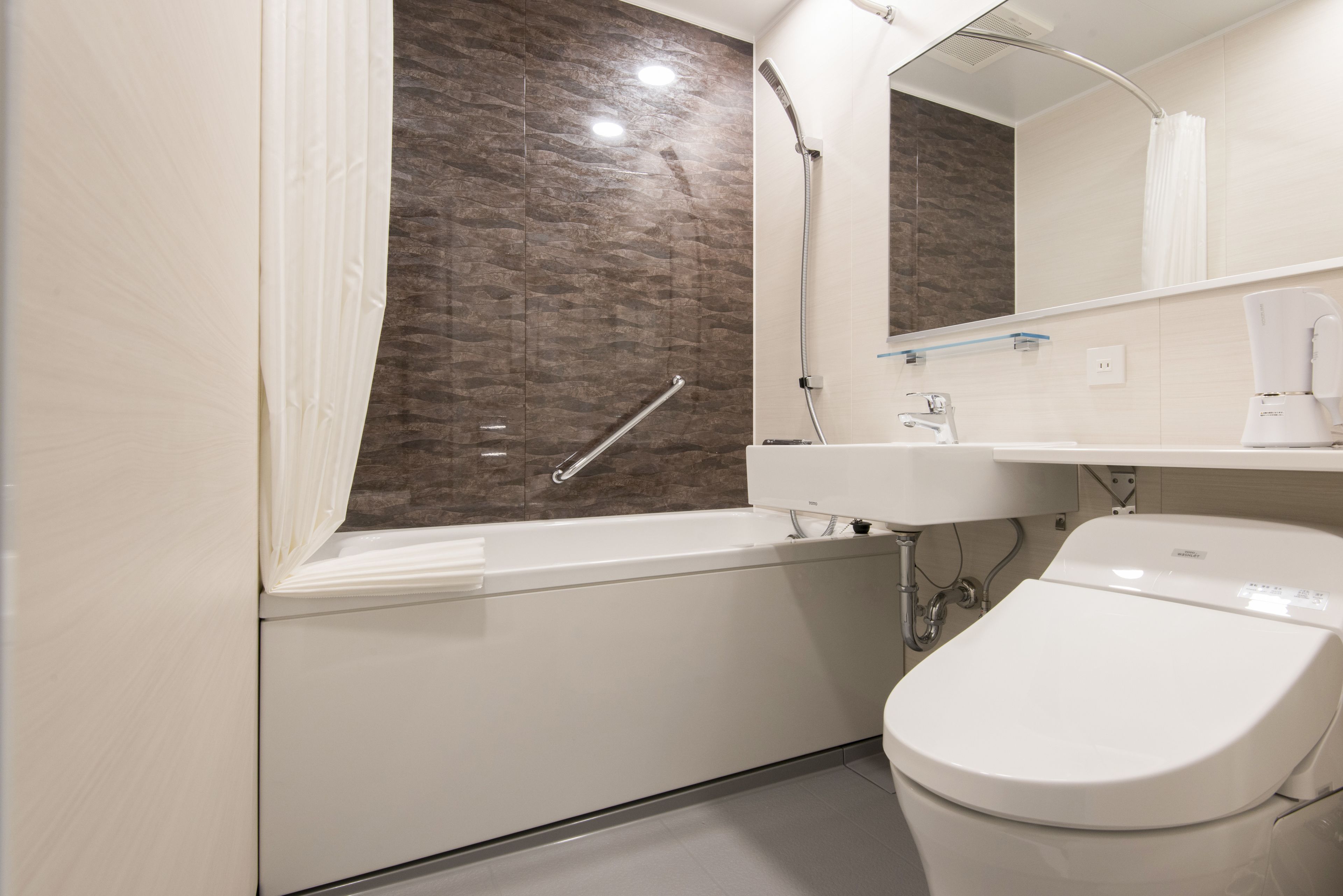 A modern bathroom with a bathtub, a toilet, a sink, and a shower.