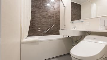 A modern bathroom with a bathtub, a toilet, a sink, and a shower.