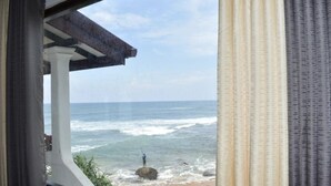 Vista do oceano a partir de uma área externa coberta, com uma pessoa pescando.
