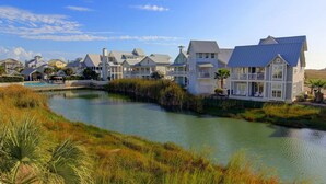 A waterfront property with multiple houses, a swimming pool, and a river. - Lakefront Beach Home@Cinnamon Shore North w/ Sunset Views+Amenity Access! (Port Aransas)
