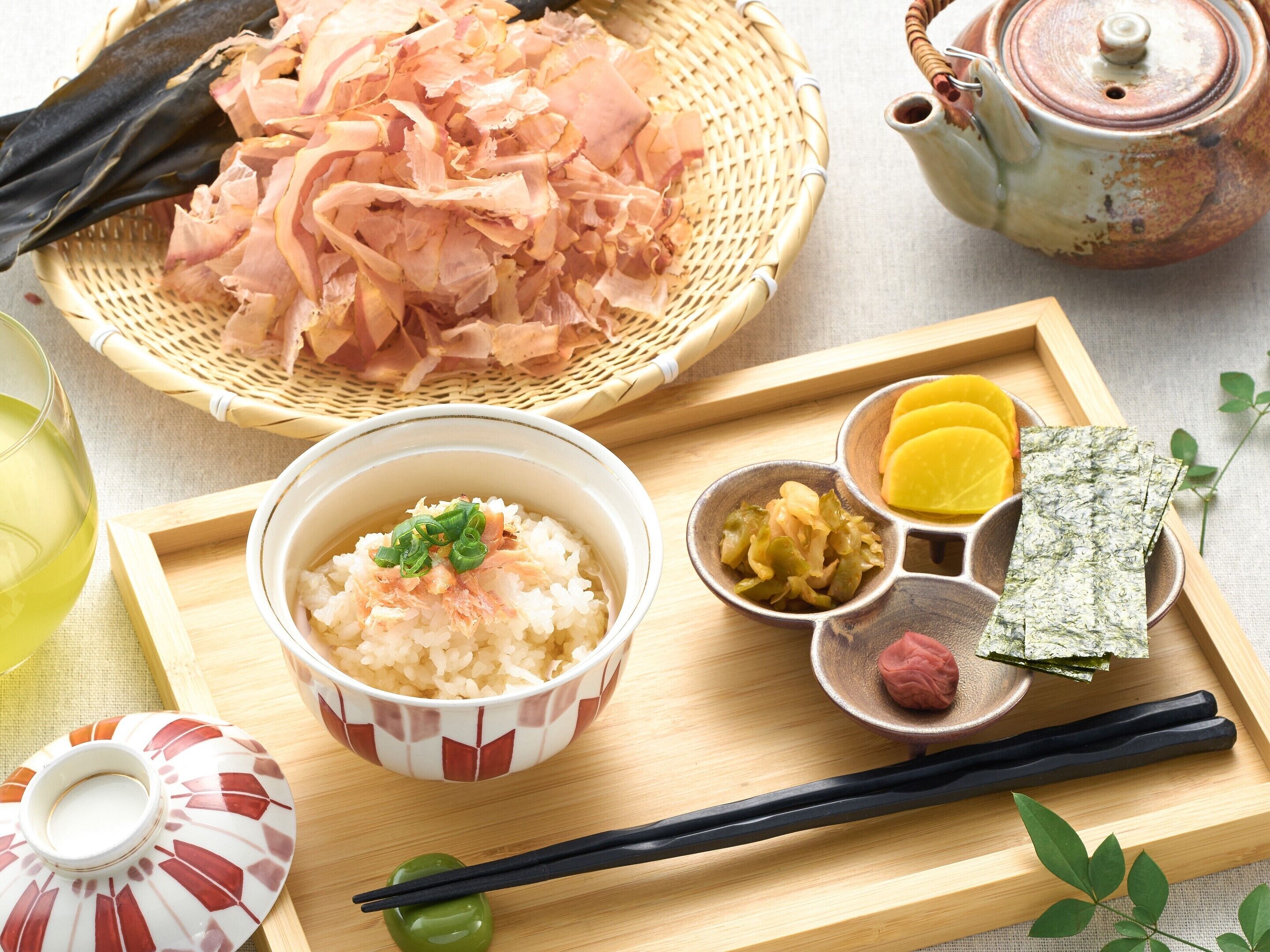 A wooden tray with a bowl of rice, pickled vegetables, and a small dish of fish.