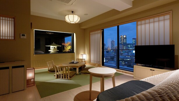 Habitación de hotel moderna con vista a la ciudad, zona de comedor y televisión.
