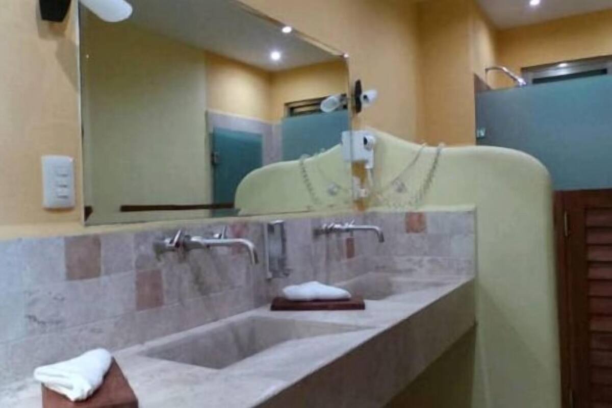 Un baño con lavamanos de mármol, un espejo y una toalla en el mostrador.