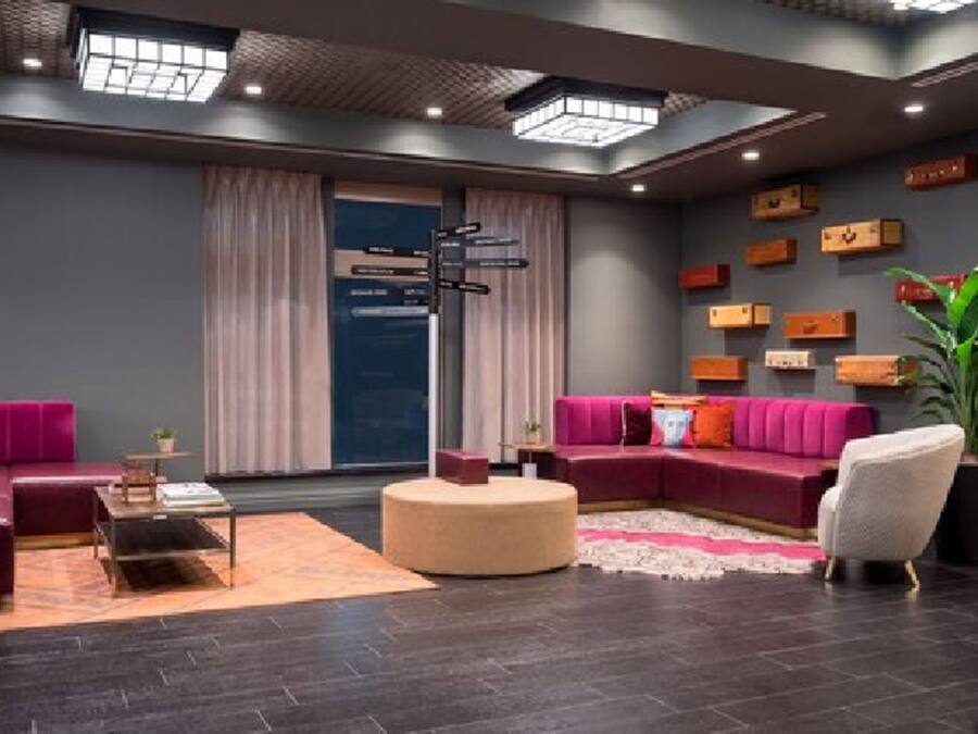 Una sala moderna con un sofá modular, un reposapiés redondo y una mesa de centro.