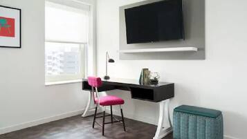 Um espaço de escritório moderno com uma mesa, cadeira e uma televisão fixada na parede.