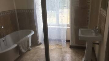 A bathroom with a bathtub, a sink, and a shower.