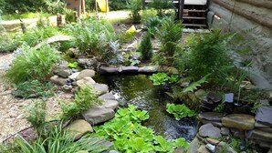 A garden with a pond, surrounded by rocks and various plants.