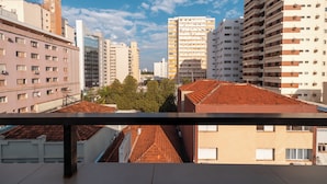 A cityscape with multiple high-rise buildings, a clear sky, and a balcony railing. - Hotel Metrópolis (São José do Rio Preto)