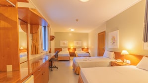 A hotel room with two beds, a desk, a chair, a wardrobe, and a bathroom. - Hotel Metrópolis (São José do Rio Preto)