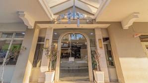 A hotel entrance with a 'METROPOLIS' sign, a glass door, and potted plants. - Hotel Metrópolis (São José do Rio Preto)