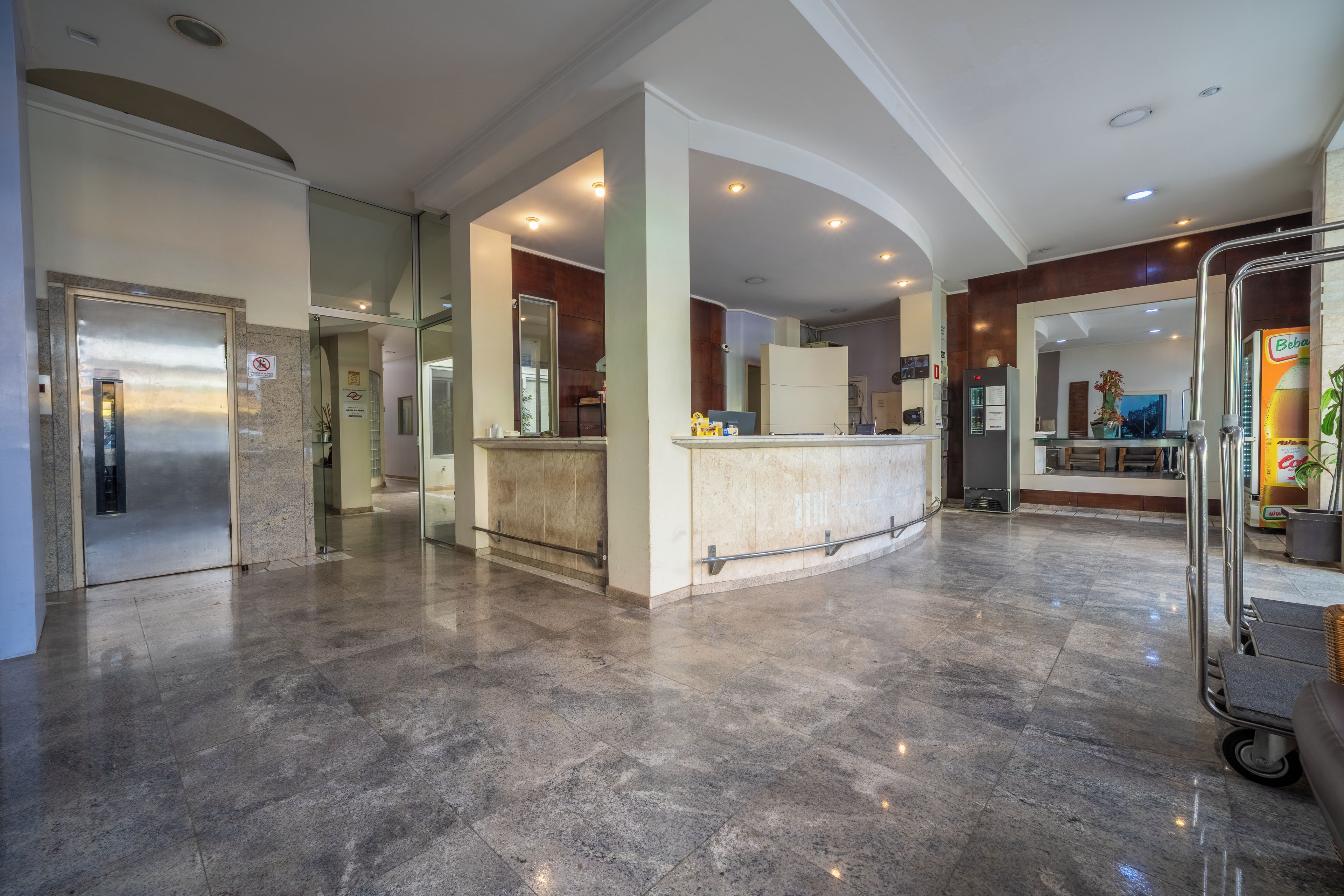 Eine geräumige Lobby mit Marmorboden, einer Rezeption und einem Kühlschrank.