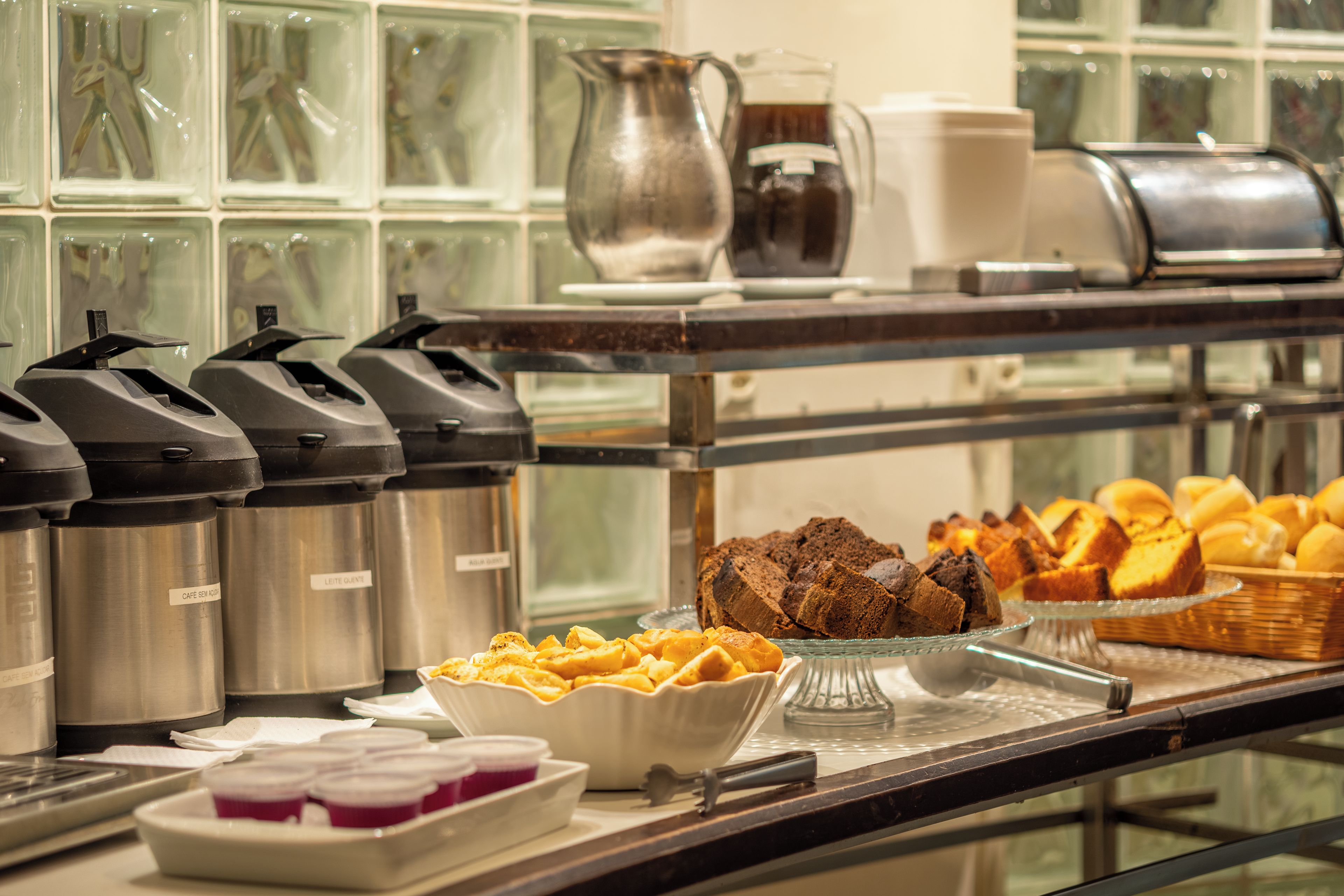 Una barra de buffet con diversos alimentos y dispensadores de bebidas.