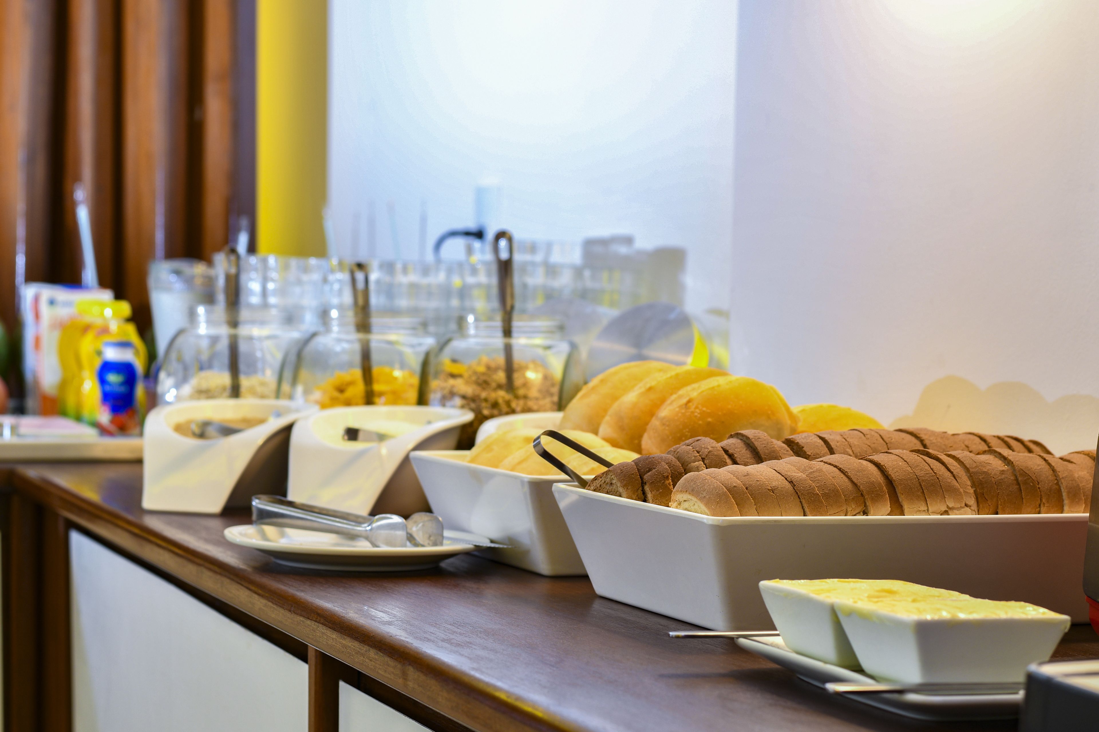 A buffet with various food items including bread, cheese, and condiments.