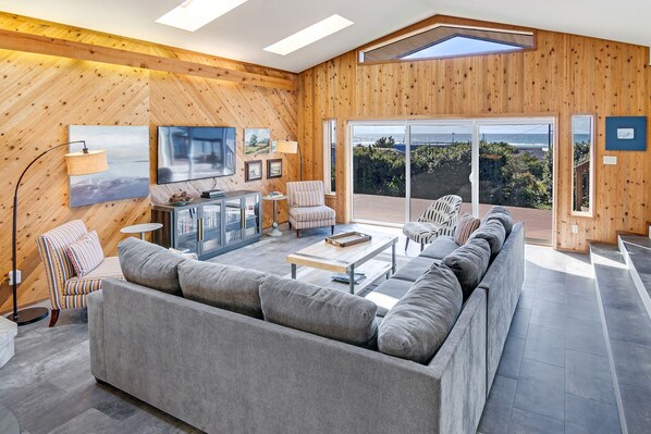 Gather in this spacious sunny living room with deck access and ocean views.