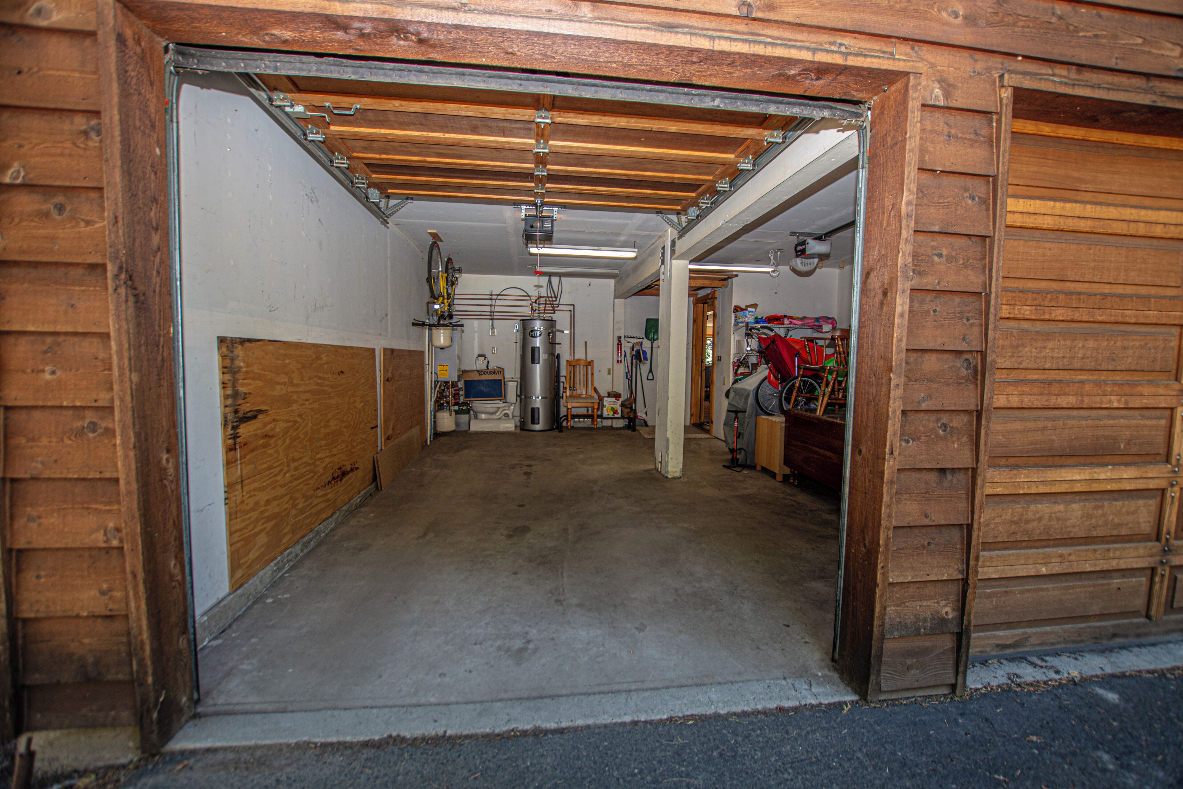 Ett garage med ett betonggolv, träväggar och ett tak av metall.