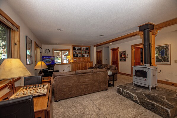 A living room with a fireplace, a sofa, a coffee table, and a board game.