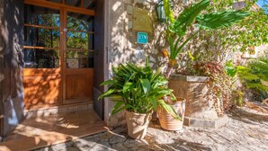A stone building with a wooden door, potted plants, and a street sign. - CA NA CARME (CA NA CARME ALARONERA) - Chalet for 4 people in Alaro. Free WiFi (Alaró)