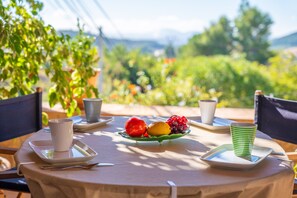 A table set with a fruit plate, a cup, and a striped cup, with a view of greenery and mountains in the background. - CA NA CARME (CA NA CARME ALARONERA) - Chalet for 4 people in Alaro. Free WiFi (Alaró)