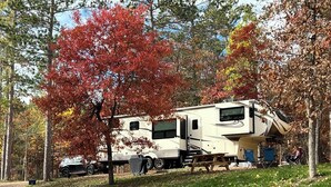 A recreational vehicle parked in a wooded area. - Luxury RV at Bolton Bay on Long Lake (Park Rapids)