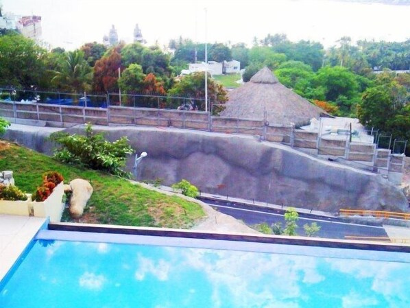 Een buitenzwembad, ligstoelen bij het zwembad