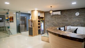 A modern reception area with a wooden reception desk, a stone wall, and a glass partition. - Hotel San Gabriel (Barrancabermeja)