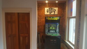 Ein Zimmer mit Holztür, Ziegelwand und einer Spielautomateneinrichtung.
